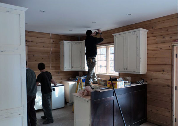 Installing the kitchen cabinets.