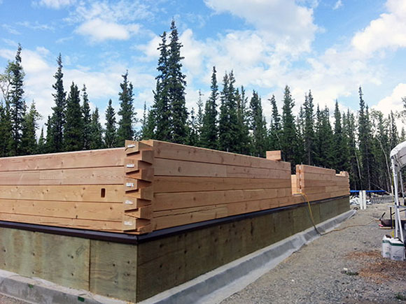 Pre-cut, pre-drilled log wall system -- saves considerable man hours on site.